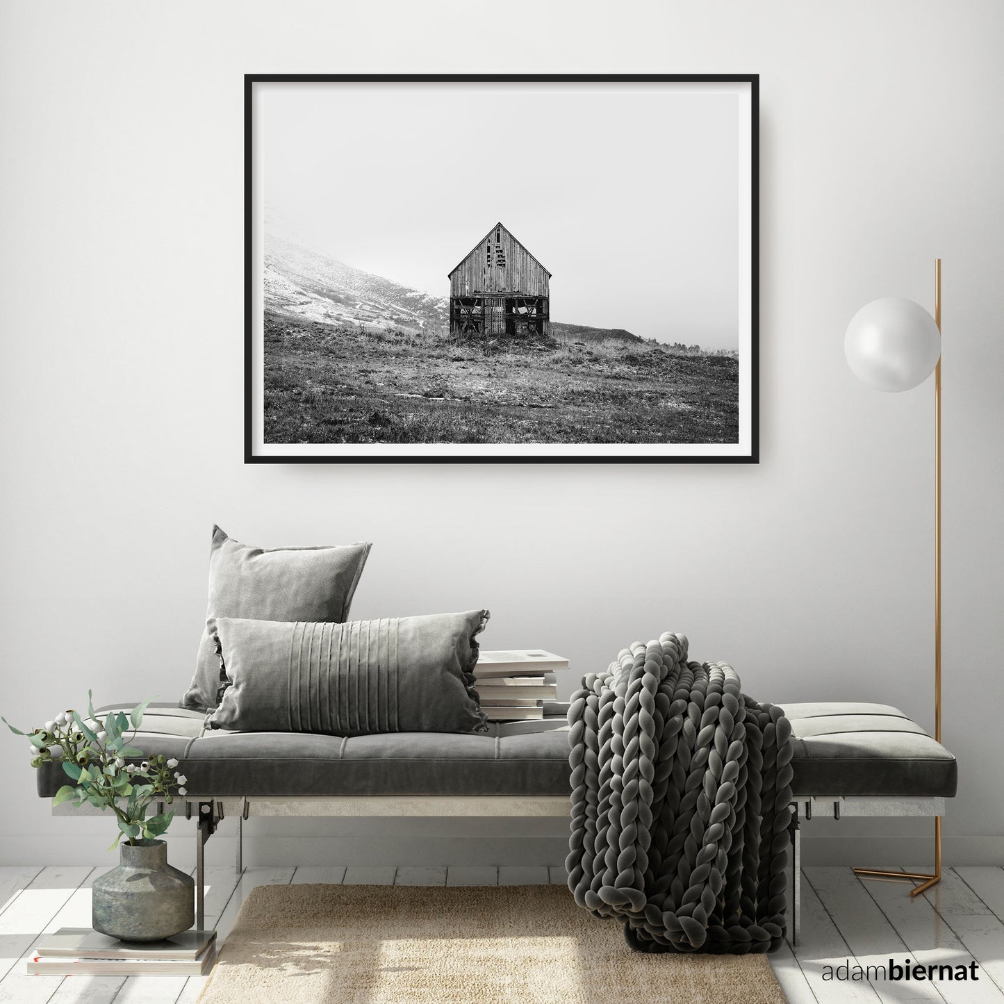Living room with a gray sofa, decorative pillows, and a framed black and white fine art photography by Adam Biernat.